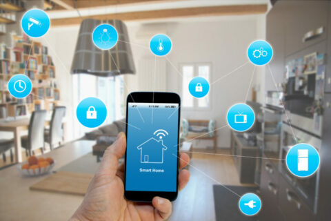 eine Hand hält ein Smartphone mit einer App smart home