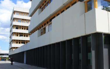 zwei hohe Gebäude mit gelb gerahmten Fenstern