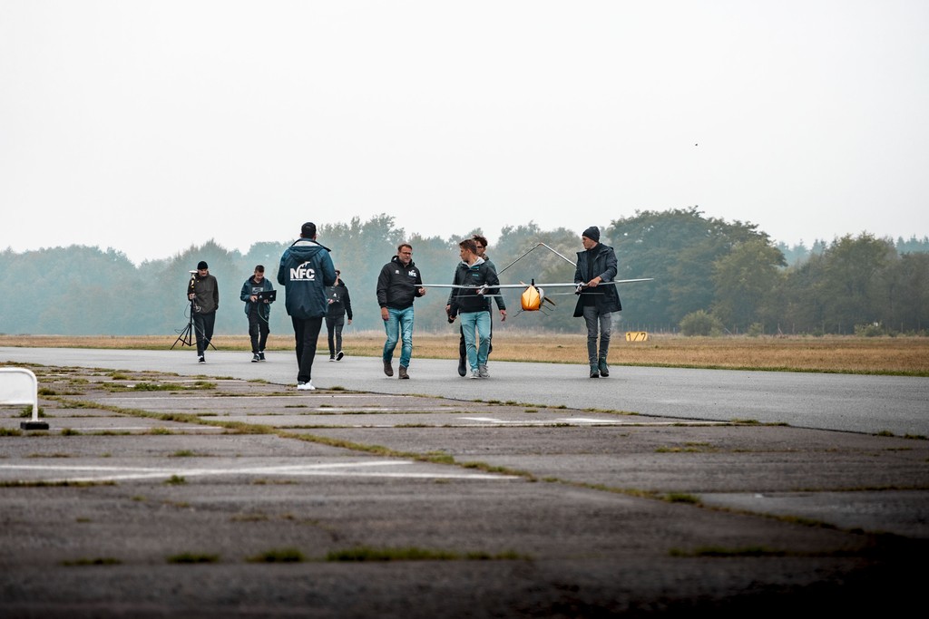 Mitglieder der Hochschulgruppe Evolonic tragen das Flugzeug auf die Landebahn