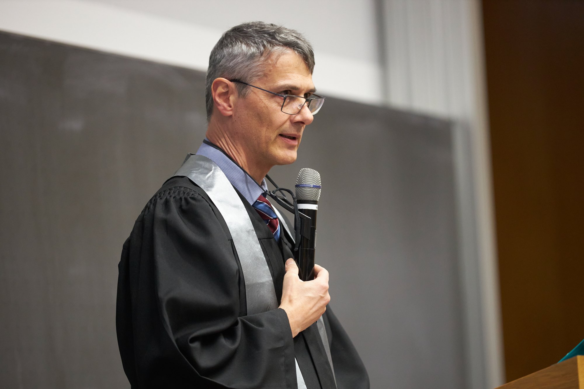 Eine Person im feierlichen Talar hält eine Rede.