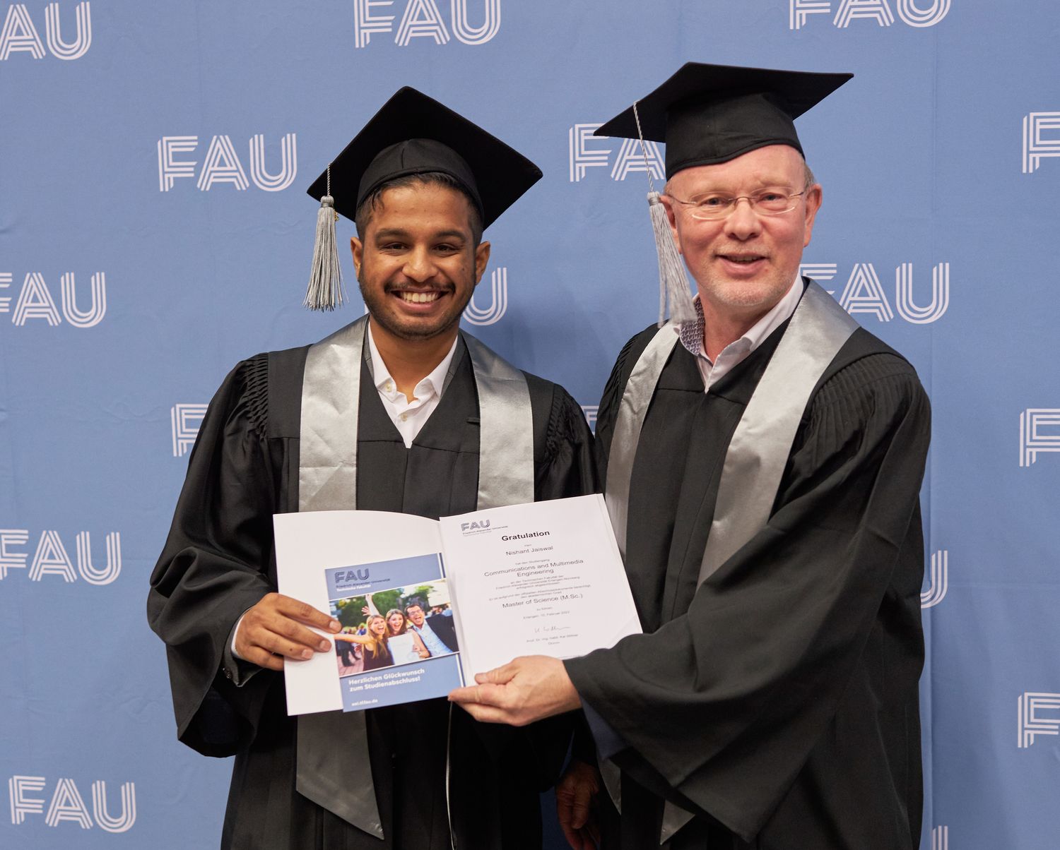 Überreichung der Urkunde an einen Absolventen.