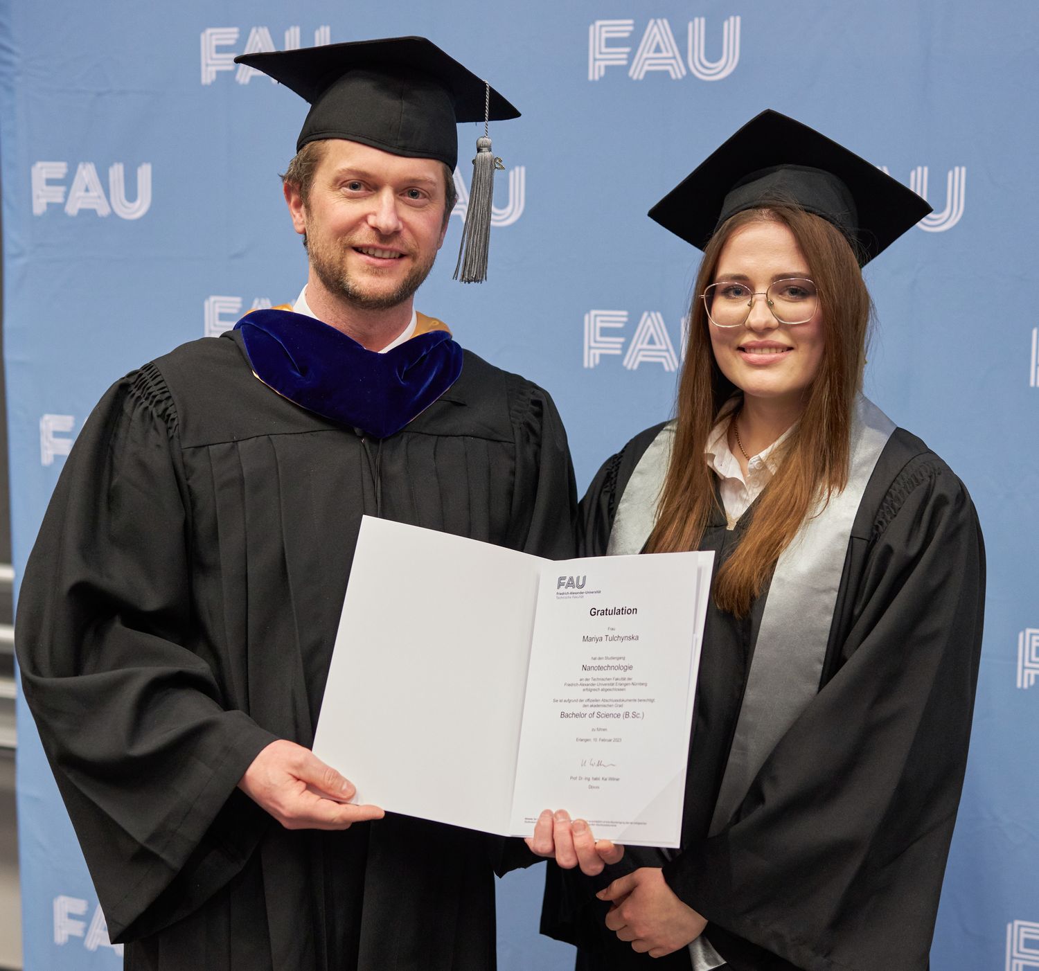 Überreichung der Urkunde an eine Absolventin.