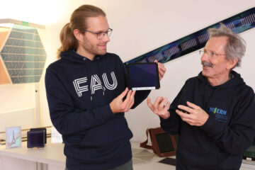 Dr. Andreas Distler (l.) und Dr. Hans-Joachim Egelhaaf mit dem organischen Photovoltaikmodul in der Hand