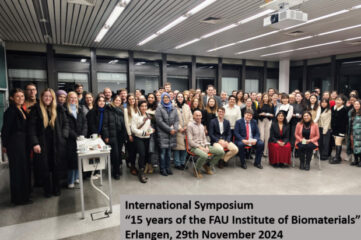 Gruppenbild von vielen Personen, die nebeneinander stehen und sitzen und alle in die Kamera schauen.